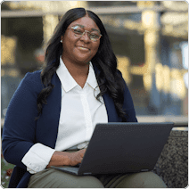 woman sitting on park bench with laptop