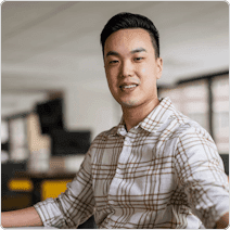 man sitting at desk stairing into camera